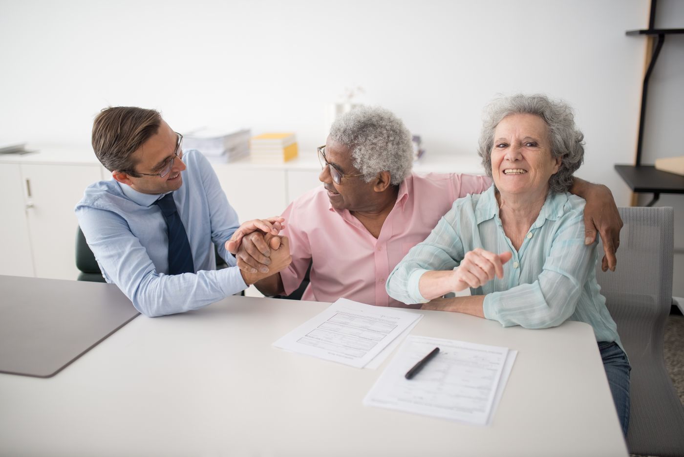 An advisor sitting with a smiling senior couple