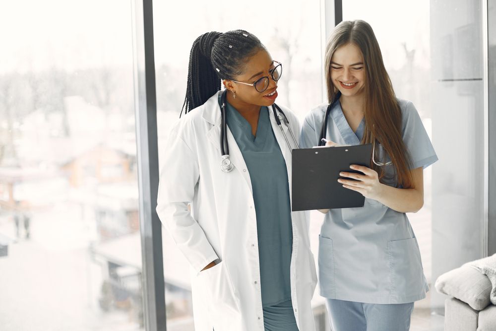 Two healthcare professionals reviewing a clipboard