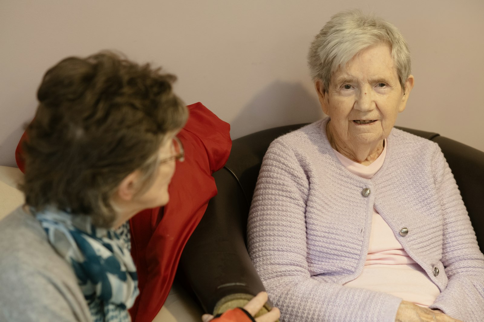 A senior woman at home talking with a visitor